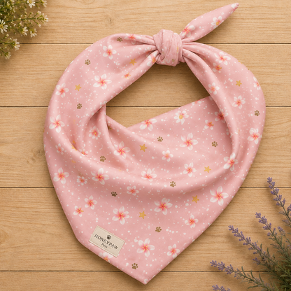 Aloha Paws dog bandana featuring pink plumeria flowers, paw prints, and golden stars on a blush pink background by HoneyPaw Pets.
