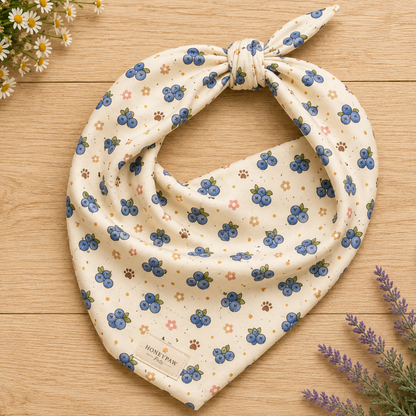 Blueberry Barkin' dog bandana featuring fresh blueberries, floral accents, and paw prints on a cream background by HoneyPaw Pets.