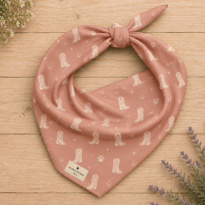 Country Pup western dog bandana featuring western cowboy boots, horseshoes, and paw prints on a blush pink background by HoneyPaw Pets.