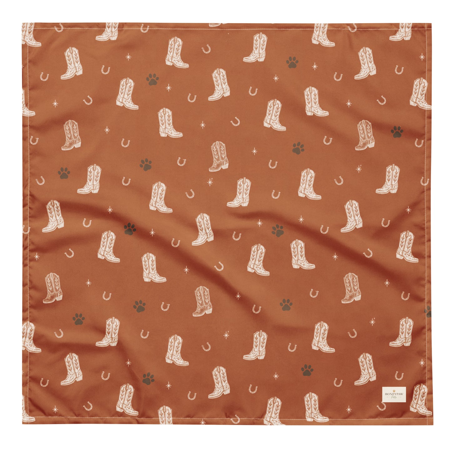 Cowboy Rover western dog bandana featuring western cowboy boots, horseshoes, and paw prints on a burnt orange background by HoneyPaw Pets.