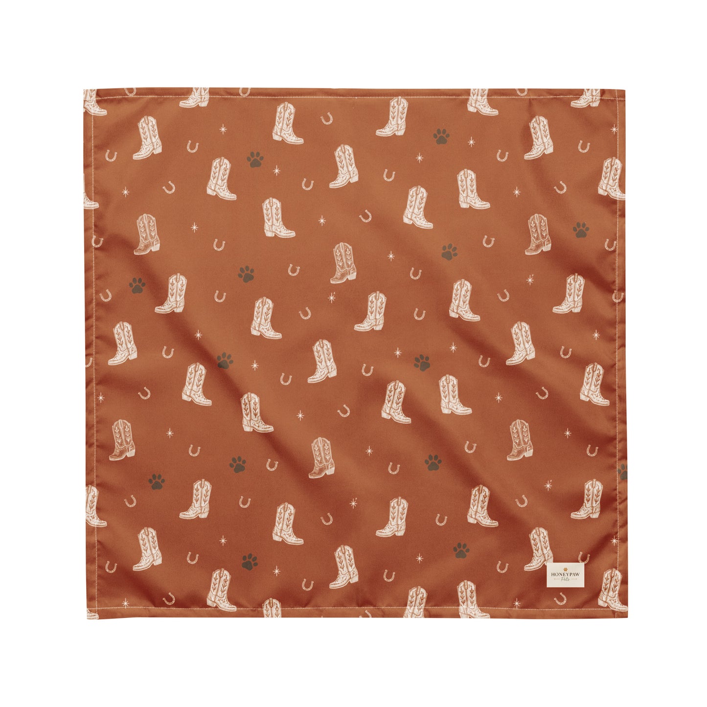 Cowboy Rover western dog bandana featuring western cowboy boots, horseshoes, and paw prints on a burnt orange background by HoneyPaw Pets.