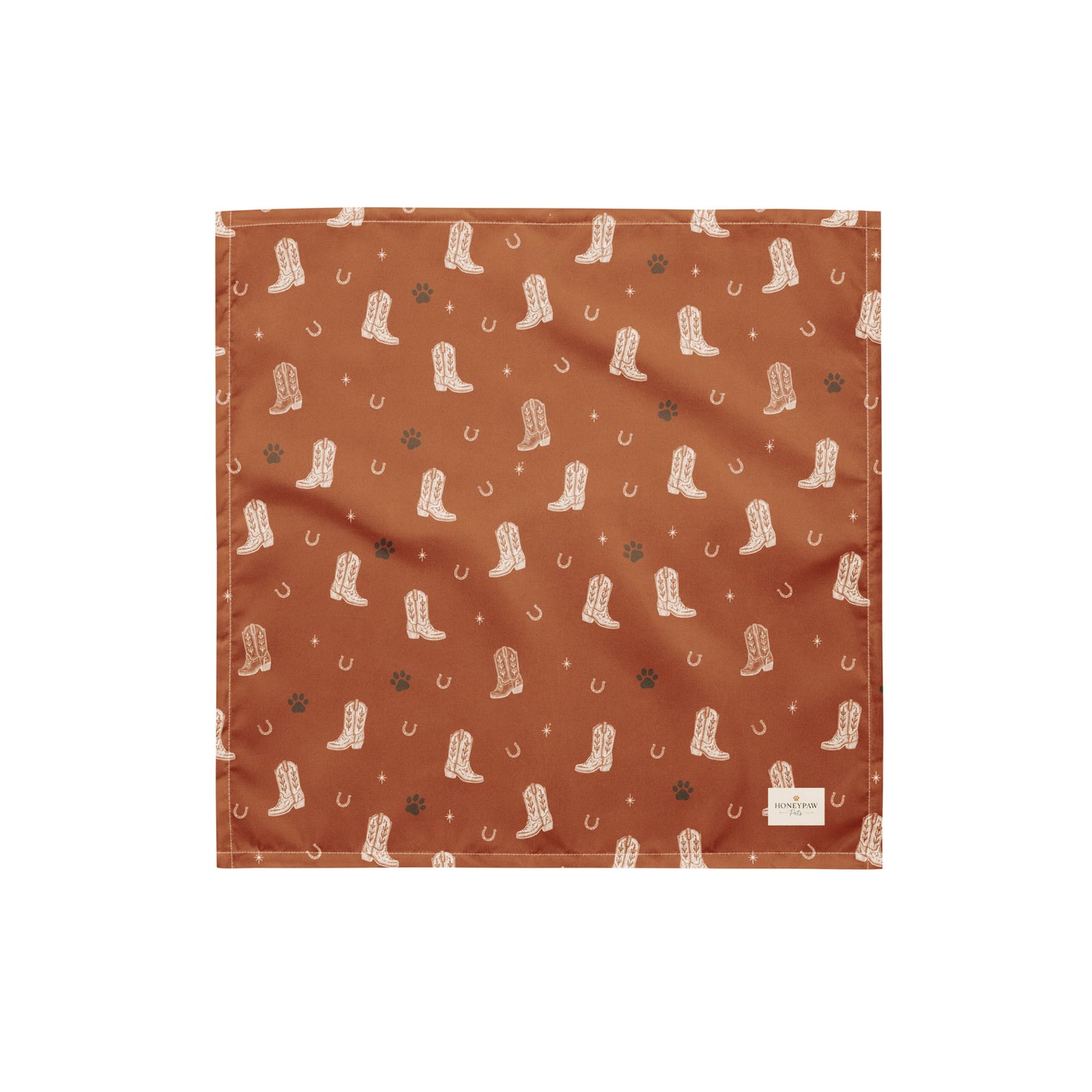 Cowboy Rover western dog bandana featuring western cowboy boots, horseshoes, and paw prints on a burnt orange background by HoneyPaw Pets.
