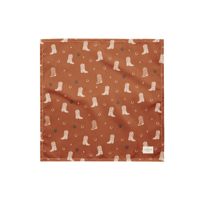 Cowboy Rover western dog bandana featuring western cowboy boots, horseshoes, and paw prints on a burnt orange background by HoneyPaw Pets.