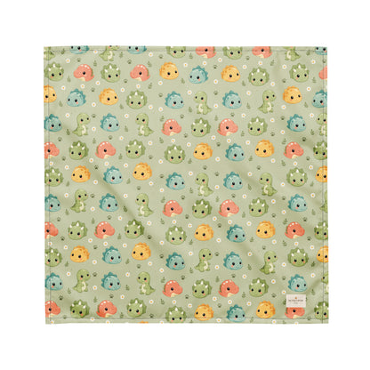 Dino Days dog bandana featuring colorful dinosaur faces and paw prints on a sage green background by HoneyPaw Pets
