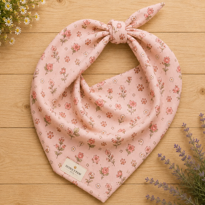 Feeling Rosy dog bandana featuring a blush pink background with delicate rose floral prints and paw print accents by HoneyPaw Pets.