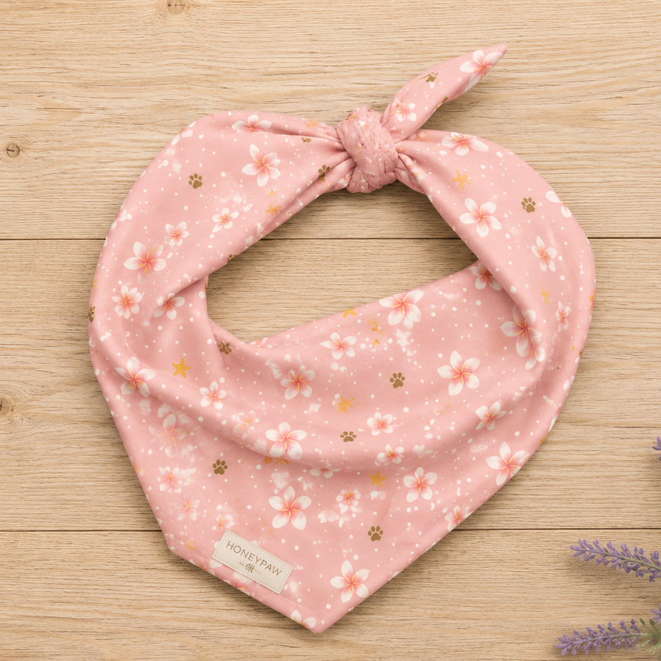 Display photo of a pink floral HoneyPaw Pets dog bandana on a wood background