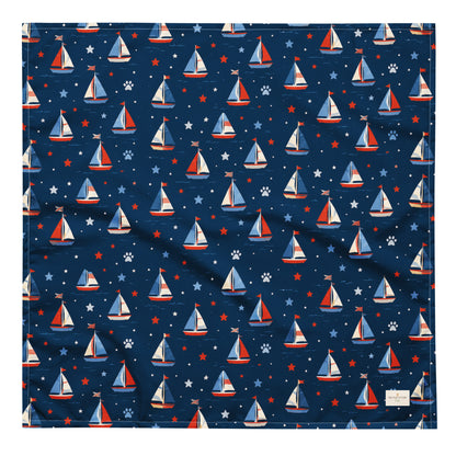 Paws at Sea dog bandana featuring a nautical sailboat pattern on a navy blue background by HoneyPaw Pets.