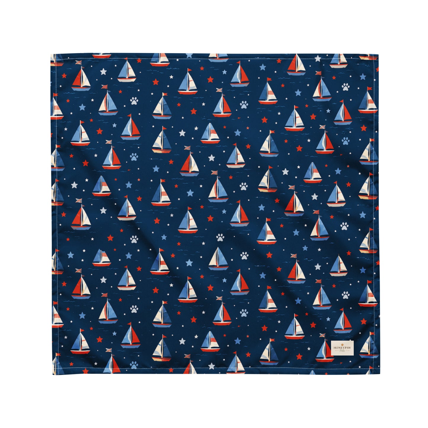 Paws at Sea dog bandana featuring a nautical sailboat pattern on a navy blue background by HoneyPaw Pets.