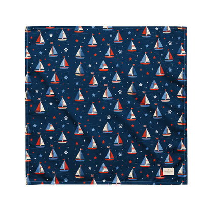 Paws at Sea dog bandana featuring a nautical sailboat pattern on a navy blue background by HoneyPaw Pets.