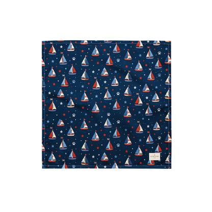 Paws at Sea dog bandana featuring a nautical sailboat pattern on a navy blue background by HoneyPaw Pets.
