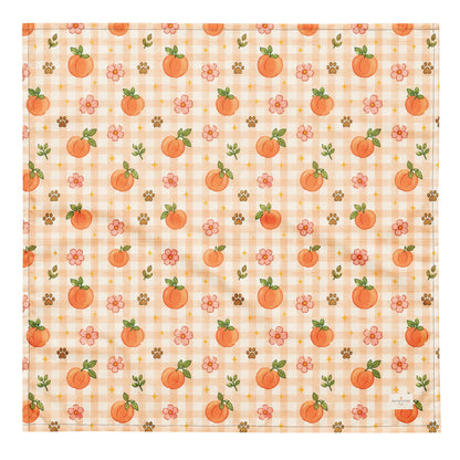 Peachy Pup dog bandana featuring ripe peaches, floral accents, and a soft peach plaid pattern on a cream background by HoneyPaw Pets.