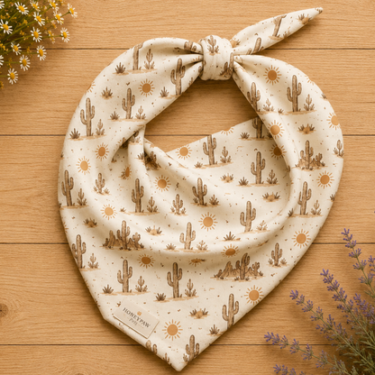 Prickly Pup dog bandana featuring a cream background with hand-drawn desert cacti, sunshine motifs, and southwestern-inspired details in warm earth tones by HoneyPaw Pets.