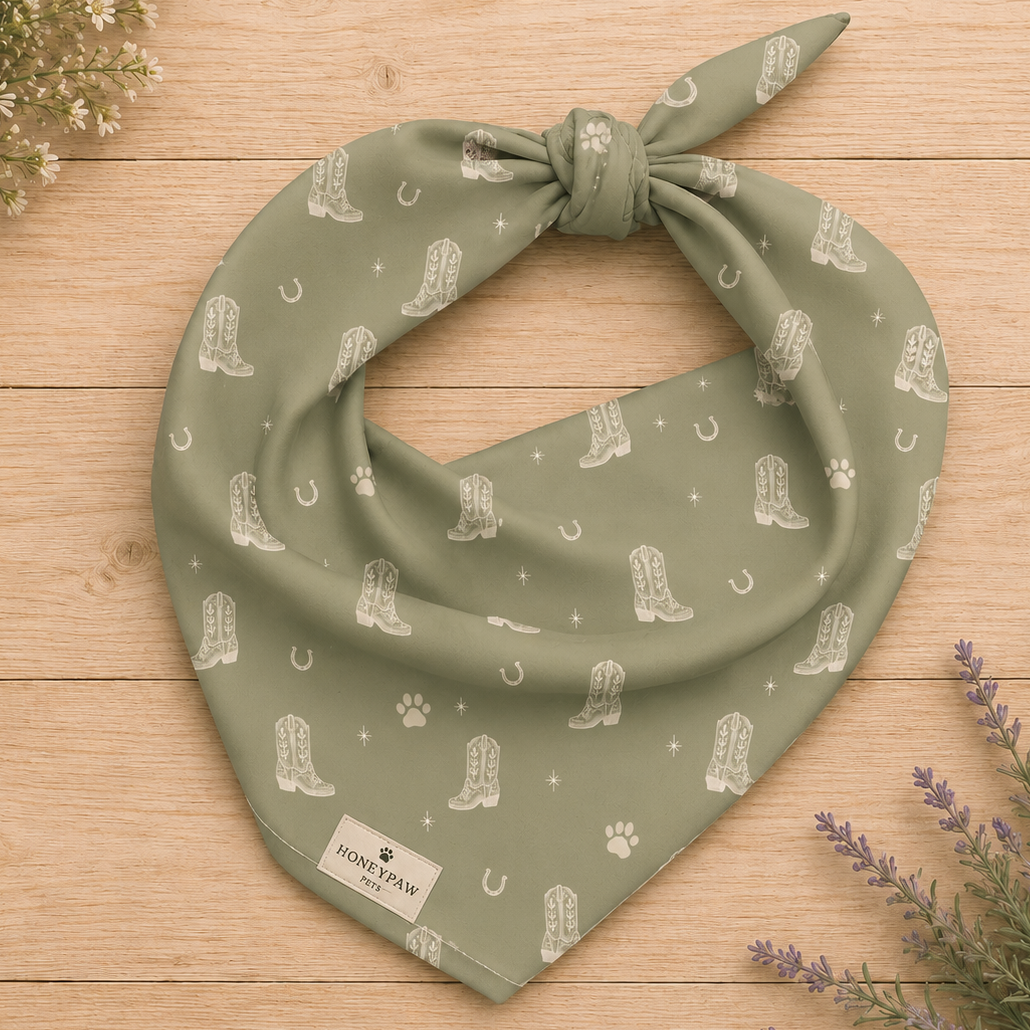 Rodeo Print western dog bandana featuring western cowboy boots, horseshoes, and paw prints on a sage green background by HoneyPaw Pets.