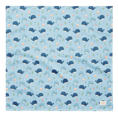 Seaside Friends ocean-themed dog bandana featuring dolphins, whales, and paw prints on a blue background by HoneyPaw Pets