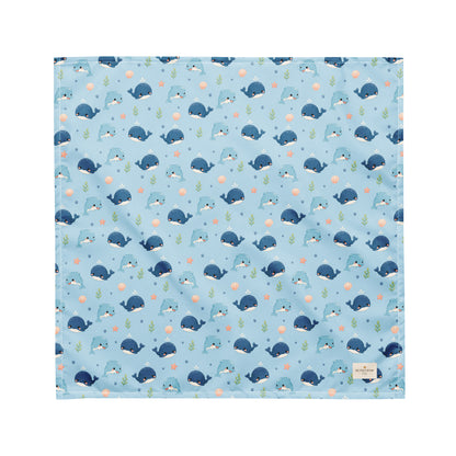 Seaside Friends ocean-themed dog bandana featuring dolphins, whales, and paw prints on a blue background by HoneyPaw Pets