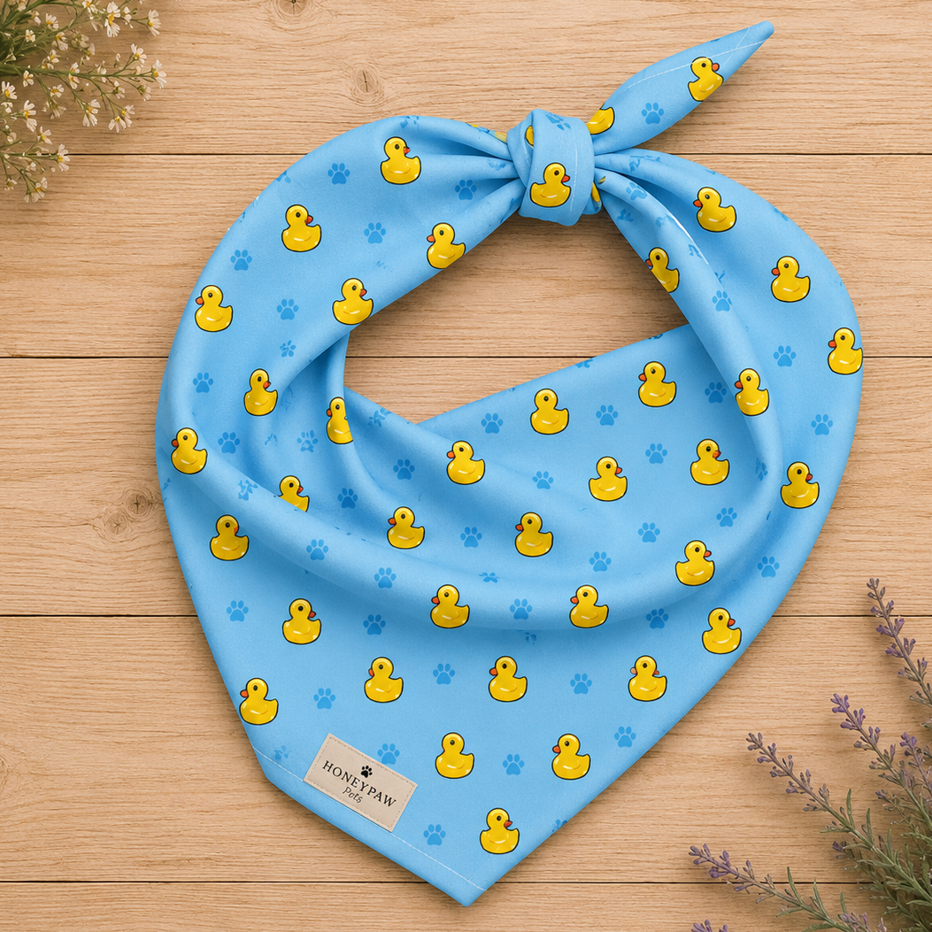 Splish Splash duck dog bandana featuring rubber ducks and paw prints on a blue background by HoneyPaw Pets