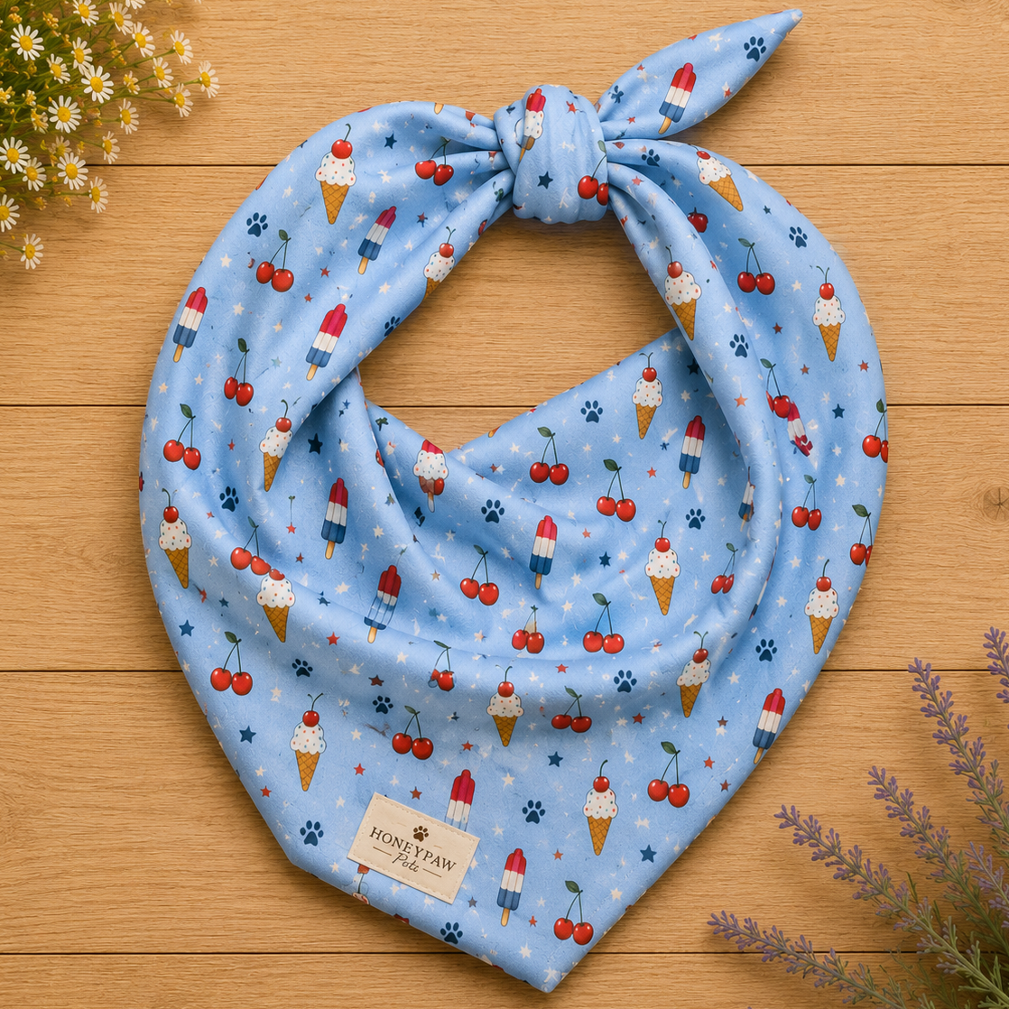 Stars and Sprinkles dog bandana featuring a patriotic ice cream and cherry pattern on a light blue background by HoneyPaw Pets.