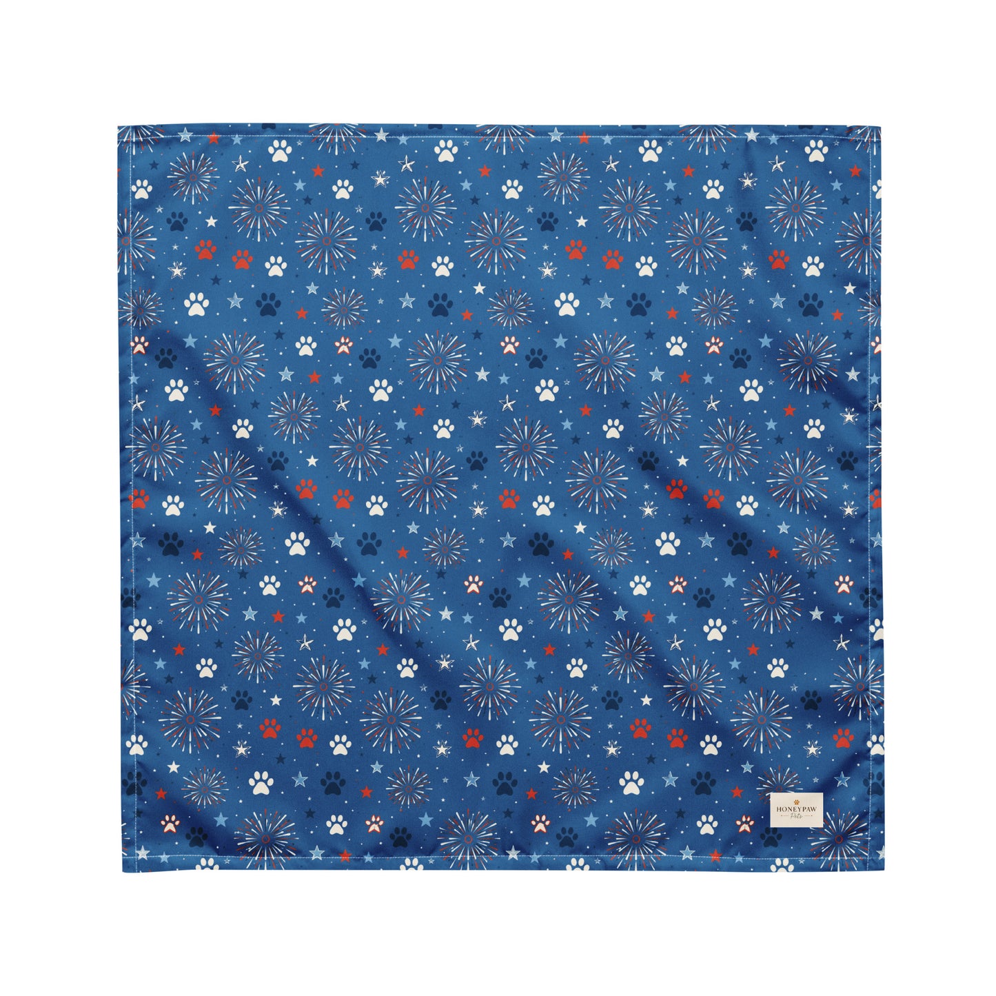 Summer Sparks dog bandana featuring red, white, and blue fireworks with paw prints on a royal blue background by HoneyPaw Pets.